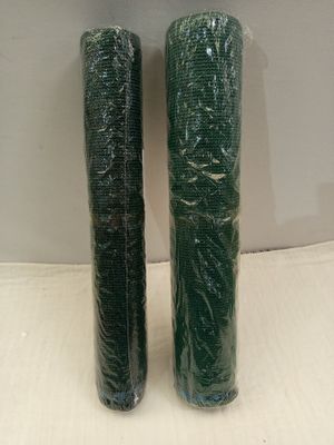 deux rouleaux de film alimentaire vert posés sur une surface blanche