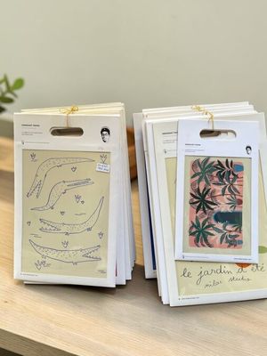 trois cartes sont posées sur une table en bois, à côté d'une plante en pot