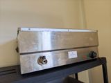 a silver oven sitting on top of a black table