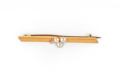a close up of a gold tie bar with pearls on it