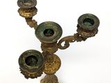 a brass candelab with three candles on it