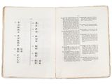 an open book with chinese writing on it on a white surface