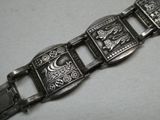 une image représentant un bracelet en argent orné d'un lion et d'une lune