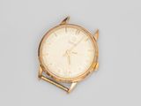 an image of a gold wrist watch on a gray surface