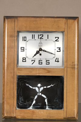 une horloge posée sur une table, à côté d'une photo d'un homme