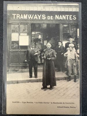 an old photo of a woman standing in front of a train station