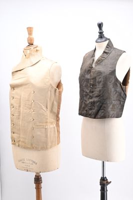 three mannequins with different types of clothing on display in a glass case