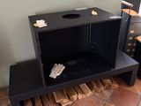 a black table with a firewood holder on top of it