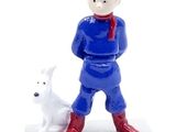 figurine of a man and a dog on a white surface