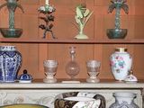 many vases and bowls on a shelf in a room