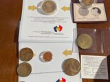 some coins are sitting on a table next to a piece of paper