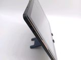 a tablet computer sitting on a stand on a white surface