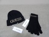 black gloves and a beanie sitting on top of a bed next to a tag