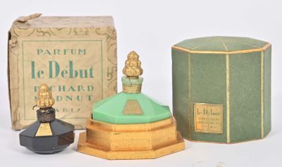 un petit flacon de parfum à côté d'une petite boîte de parfum