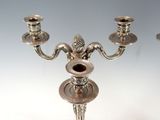 three silver candles that are sitting on a table
