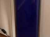 a blue vase sitting on a stand in front of a bookshelf