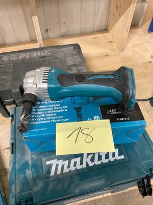 un gros plan d'une perceuse filaire posée sur une table en bois