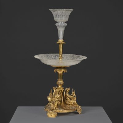 un vase en or et en cristal posé sur un socle et orné d'un oiseau