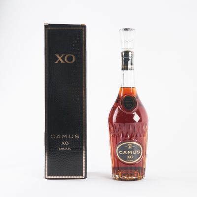 the bottle of brandy is next to the box on the table