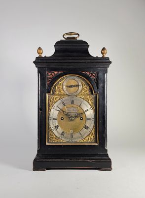 une horloge noire et dorée dont le cadran est orné de chiffres romains