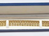 une photo d'une paire de bracelets en or dans un coffret bleu