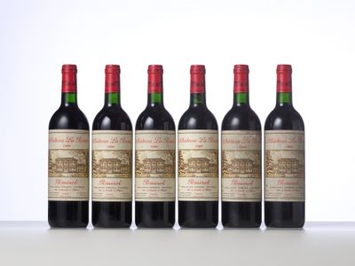 four bottles of red wine lined up in a row