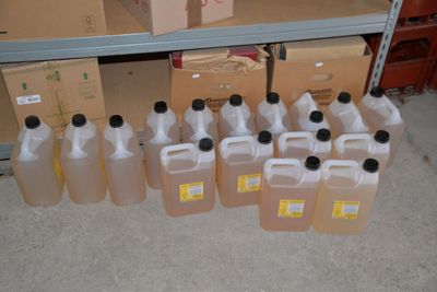 many bottles of liquid sitting on a shelf next to boxes