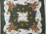 a green and white square scarf with a picture of a castle