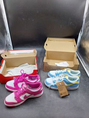 three pairs of shoes in a box on the floor