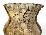 a glass vase with a design on it on a white surface