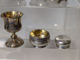 a glass display case with silver objects on it