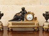 une horloge posée sur une table, à côté de trois vases
