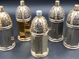 six flacons de parfum en argent et en or posés les uns à côté des autres sur une table