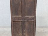 an old wooden cabinet sitting on top of a floor next to a wall