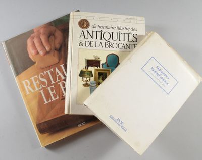 trois livres sont empilés sur une table