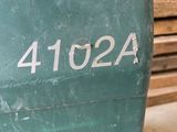a green machine that is sitting in a warehouse
