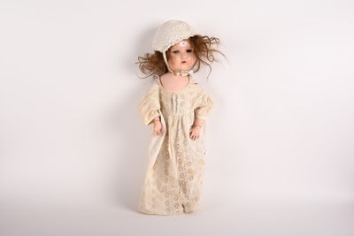 une poupée qui porte une robe et un chapeau
