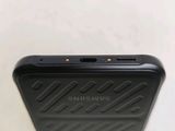 the back of a black cell phone sitting on top of a white table