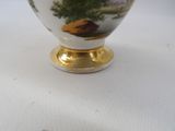 a white and gold vase with a picture of a tree on it
