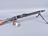 an old machine gun on a white background with a small piece of paper