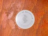 a white sticker on a wooden table that says the beely life