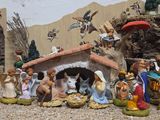 figurines of a nativity scene are displayed in front of a wall