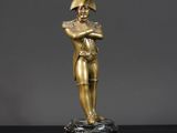 une statue en or représentant un homme tenant une batte de baseball, posée sur une table noire