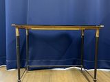 a wooden table sitting on top of a wooden floor next to a blue curtain