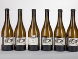 six bottles of wine are lined up on a table
