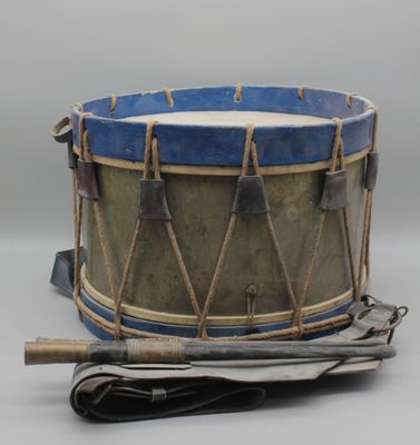 un tambour bleu et marron et un journal posés sur une table