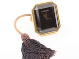 an image of a chanel watch with a tassel on a white background