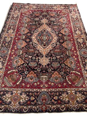 un tapis persan ancien orné d'un grand médaillon