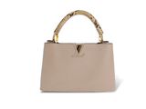 un sac à main beige avec des serpents sur la poignée