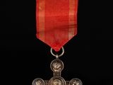 a close up of a red ribbon with a cross on it